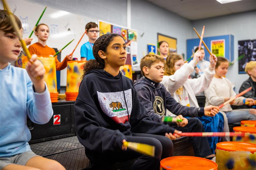 Students play drums in music class